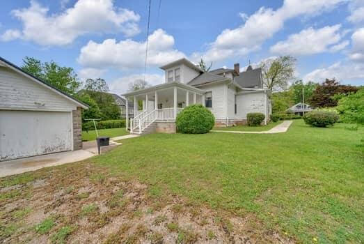 rear view of property with a lawn and covered porch