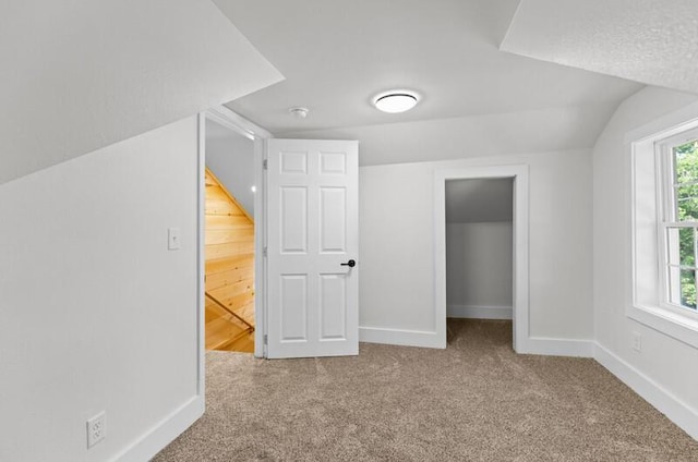 bonus room featuring plenty of natural light, light colored carpet, and lofted ceiling