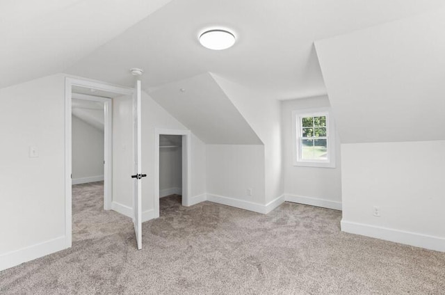 additional living space with light colored carpet and lofted ceiling