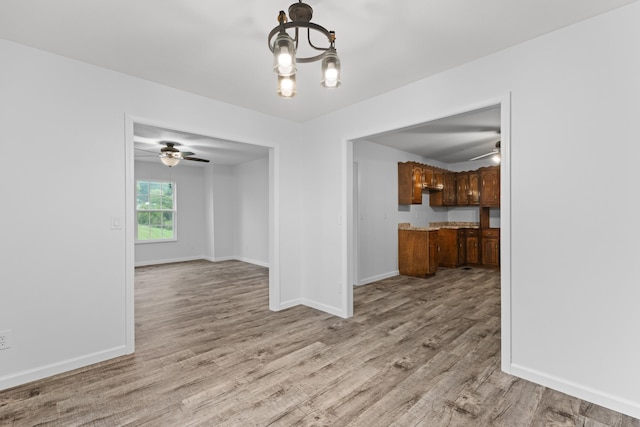 unfurnished dining area featuring a chandelier and light wood-type flooring