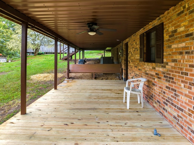 deck featuring ceiling fan and a lawn