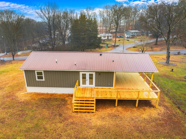 rear view of property with french doors, a yard, and a deck