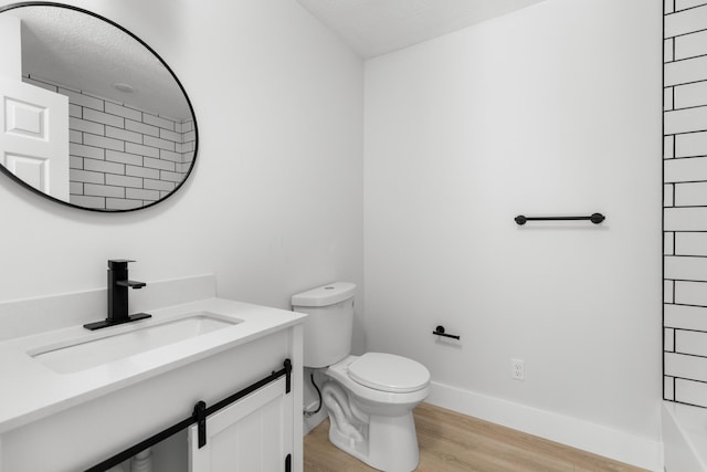 bathroom featuring vanity, hardwood / wood-style floors, a shower, and toilet