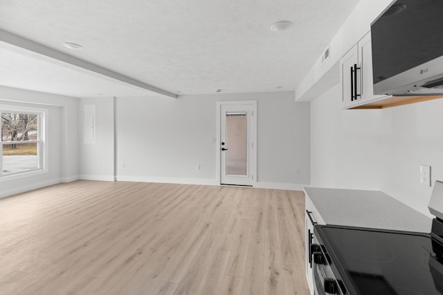 unfurnished living room with a textured ceiling and light wood-type flooring