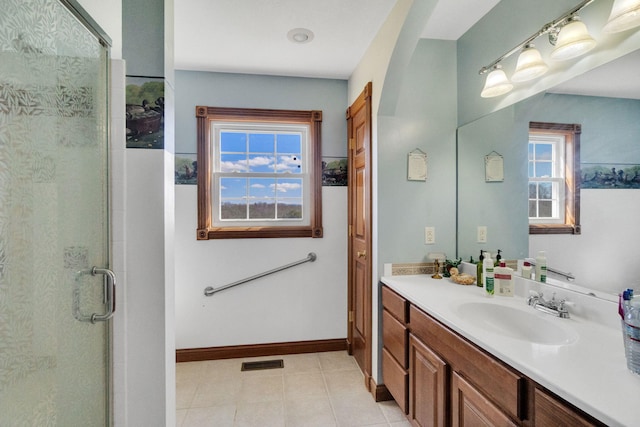 bathroom with a stall shower, visible vents, vanity, and baseboards