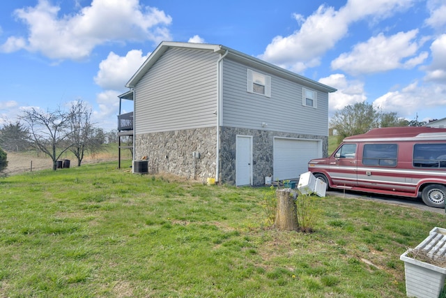 view of side of property featuring a garage and a yard