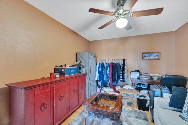 living area with ceiling fan and light hardwood / wood-style flooring