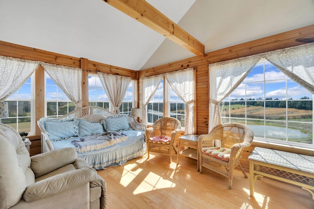 sunroom featuring vaulted ceiling with beams and a water view