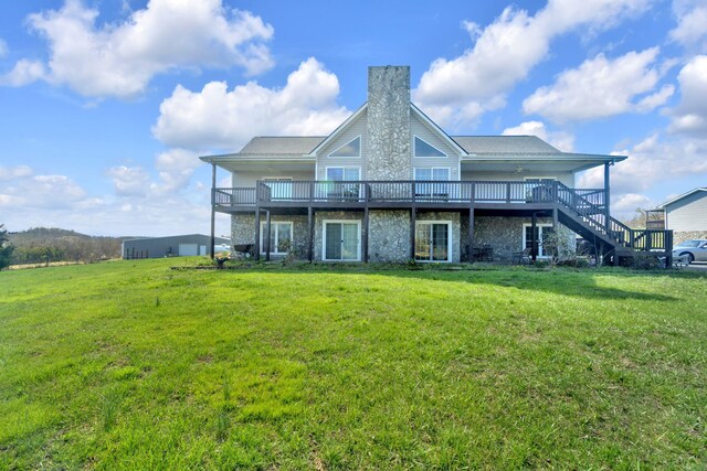 rear view of property with stone siding, a lawn, and a chimney