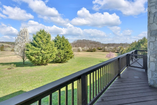 wooden terrace featuring a lawn and a rural view