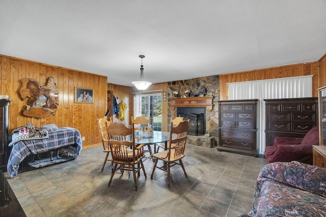 dining area with wood walls and a fireplace