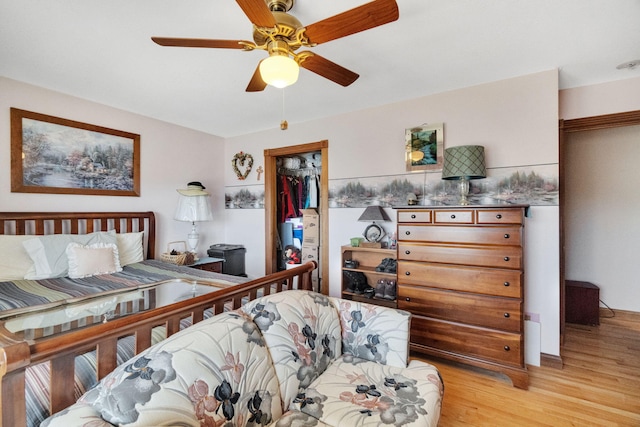 bedroom with ceiling fan, a closet, and light hardwood / wood-style floors