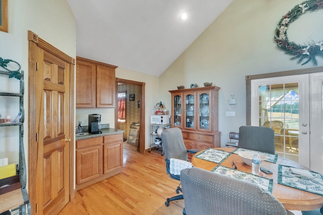 office area with light wood-type flooring and high vaulted ceiling