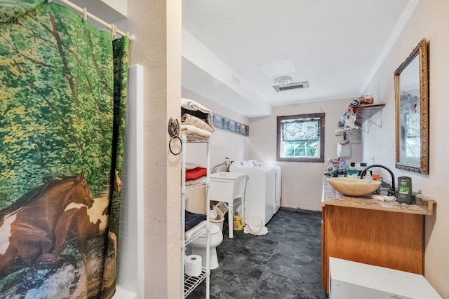 washroom with laundry area, washing machine and dryer, visible vents, and a sink