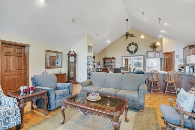 living area with high vaulted ceiling, light wood-type flooring, french doors, and ceiling fan