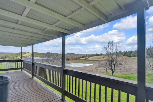 wooden terrace featuring a lawn and a water view