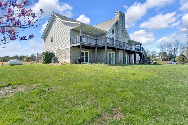 rear view of house featuring a lawn and a wooden deck