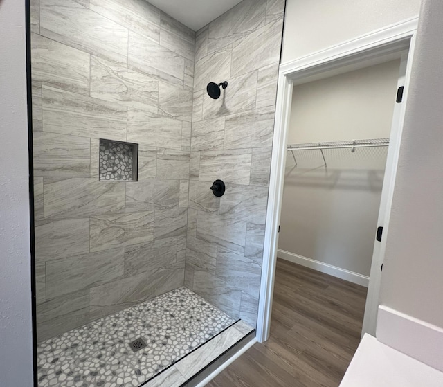 536 Sequoyah Dr, Morristown, TN 37813 - bathroom with tiled shower, wood finished floors, a walk in closet, and baseboards