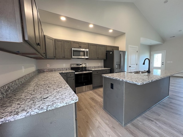 536 Sequoyah Dr, Morristown, TN 37813 - kitchen with stainless steel appliances, a sink, light wood finished floors, an island with sink, and high vaulted ceiling