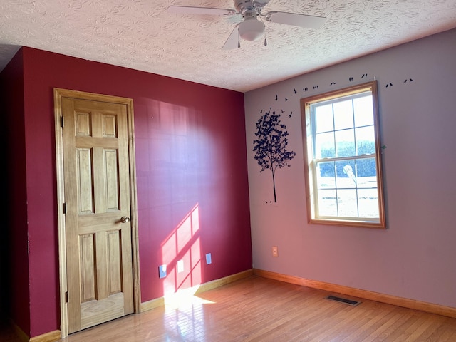 spare room featuring hardwood / wood-style flooring, a textured ceiling, and ceiling fan