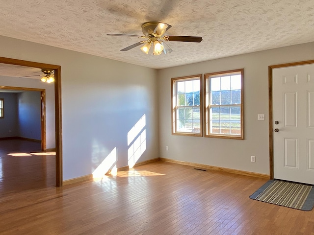 foyer featuring ceiling fan, a textured ceiling, and light hardwood / wood-style flooring