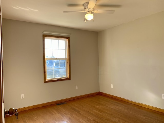 empty room with hardwood / wood-style flooring and ceiling fan