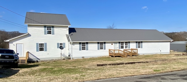 rear view of property with crawl space, metal roof, a lawn, and a deck