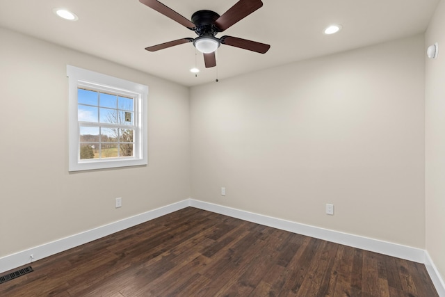 empty room featuring baseboards, dark wood-style floors, visible vents, and recessed lighting