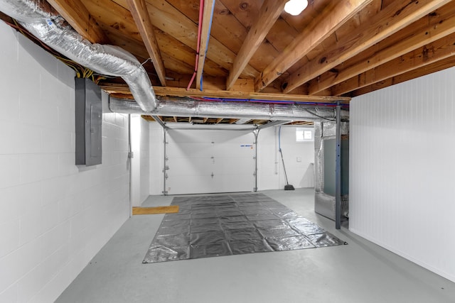 below grade area featuring concrete block wall and electric panel