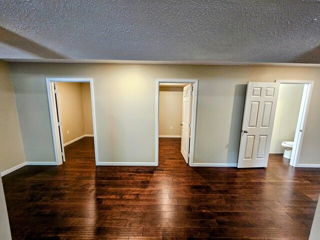 269 Buttercup Fields Rd, Newport, TN 37821 - unfurnished bedroom with a walk in closet, hardwood / wood-style flooring, baseboards, and a textured ceiling