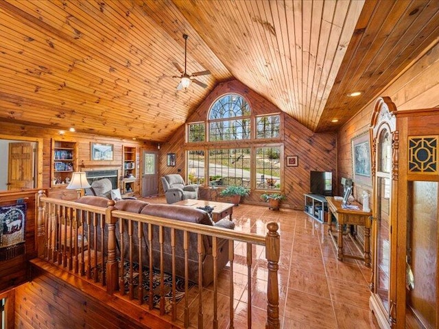 702 John Sevier Dr, Sevierville, TN 37876 - living area featuring built in shelves, a ceiling fan, wood ceiling, wooden walls, and lofted ceiling