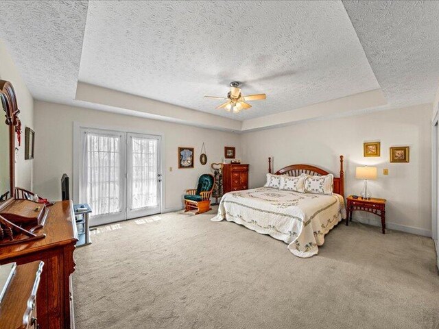 702 John Sevier Dr, Sevierville, TN 37876 - carpeted bedroom with access to outside, baseboards, a textured ceiling, a ceiling fan, and a tray ceiling