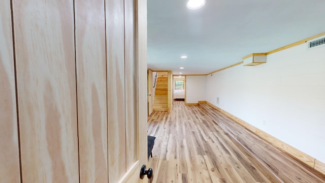 interior space with light hardwood / wood-style flooring and crown molding