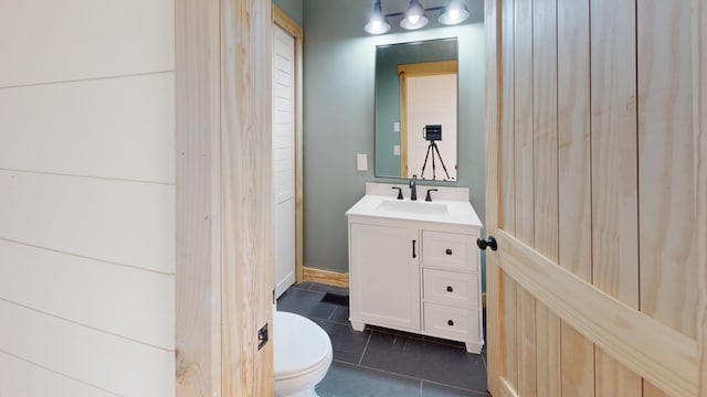 bathroom with tile patterned flooring, vanity, and toilet