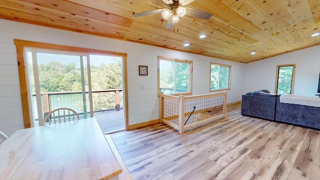 living room with wood walls, lofted ceiling, ceiling fan, light hardwood / wood-style floors, and wood ceiling