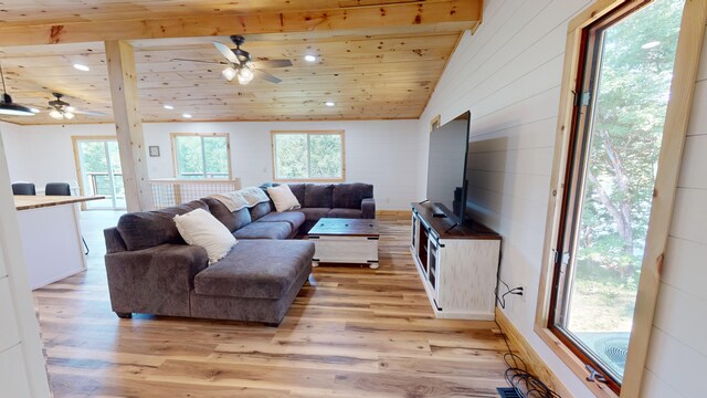 living room featuring vaulted ceiling with beams, light hardwood / wood-style floors, wood ceiling, and a wealth of natural light