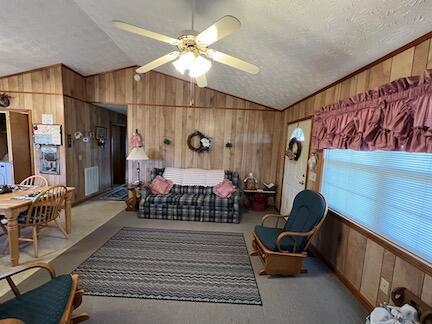 515 Mountain Lake Way, Newport, TN 37821 - carpeted living room featuring wood walls, ceiling fan, a textured ceiling, and lofted ceiling