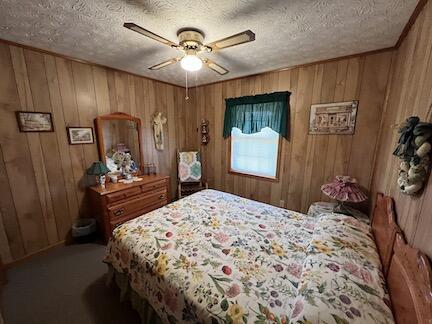 515 Mountain Lake Way, Newport, TN 37821 - bedroom with wood walls, carpet, a textured ceiling, and a ceiling fan