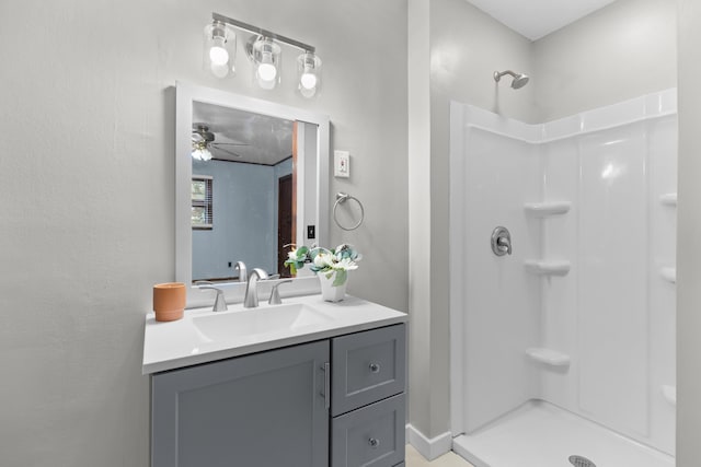 bathroom featuring ceiling fan, vanity, and walk in shower