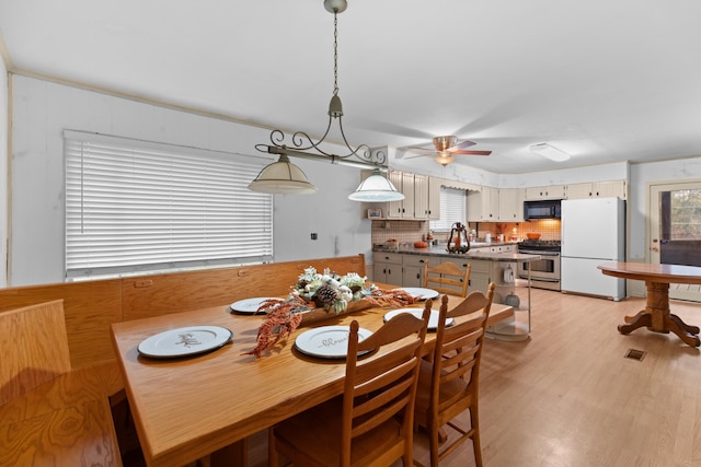 dining area featuring ceiling fan, light hardwood / wood-style floors, and a wealth of natural light