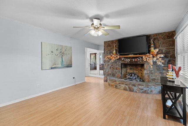 living room featuring hardwood / wood-style flooring, ceiling fan, a healthy amount of sunlight, and a fireplace