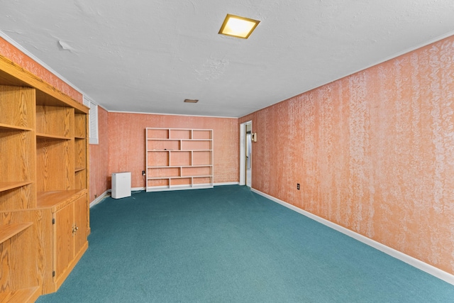 carpeted spare room featuring a textured ceiling, built in shelves, and crown molding