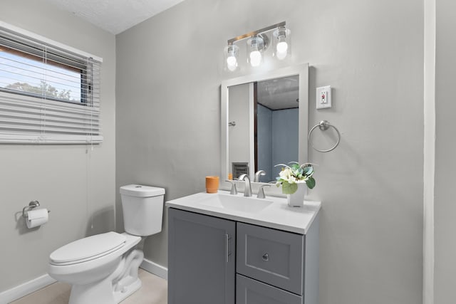 bathroom with vanity, toilet, and a textured ceiling