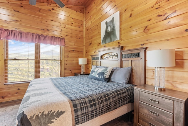 bedroom featuring multiple windows and wood walls