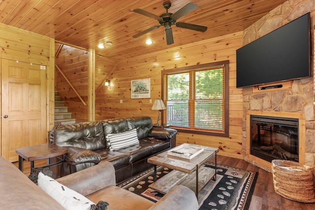 living room with wood walls, dark hardwood / wood-style floors, a stone fireplace, and wooden ceiling