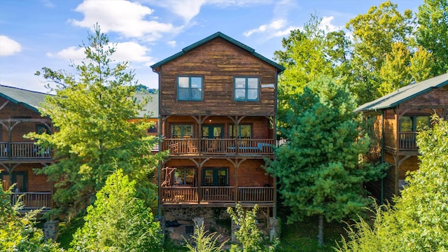 back of property featuring french doors and a balcony