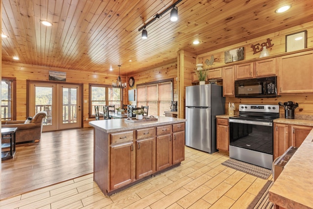 kitchen with wooden ceiling, wooden walls, a kitchen island, pendant lighting, and stainless steel appliances