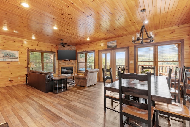 dining area with wood ceiling, wooden walls, and light hardwood / wood-style floors