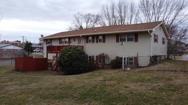 rear view of property featuring a lawn and a deck