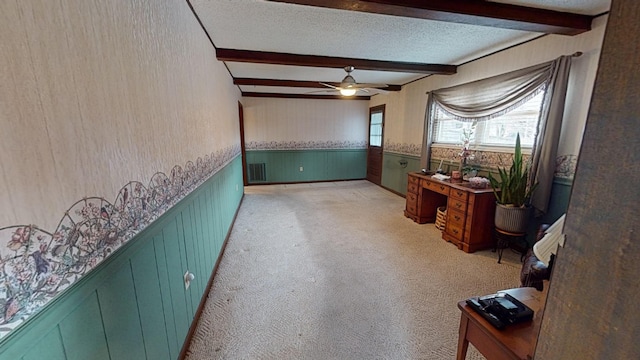 interior space with light carpet, ceiling fan, beam ceiling, and a textured ceiling